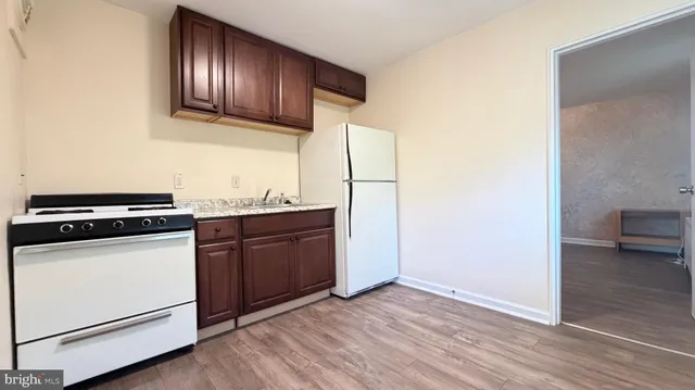 a kitchen with granite countertop wooden cabinets and white appliances