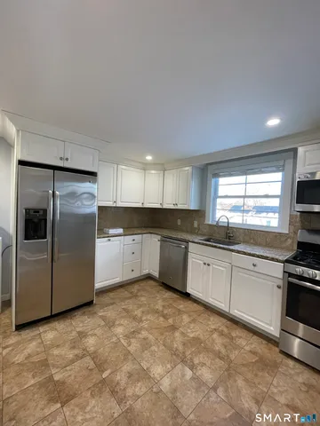 a large kitchen with a stove top oven a sink and dishwasher