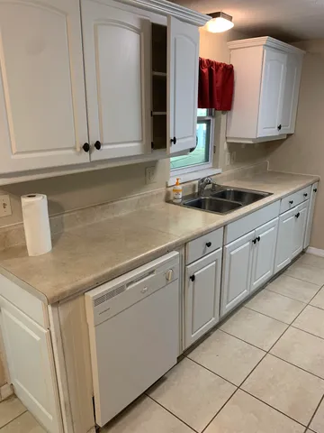 a kitchen with white cabinets and white appliances
