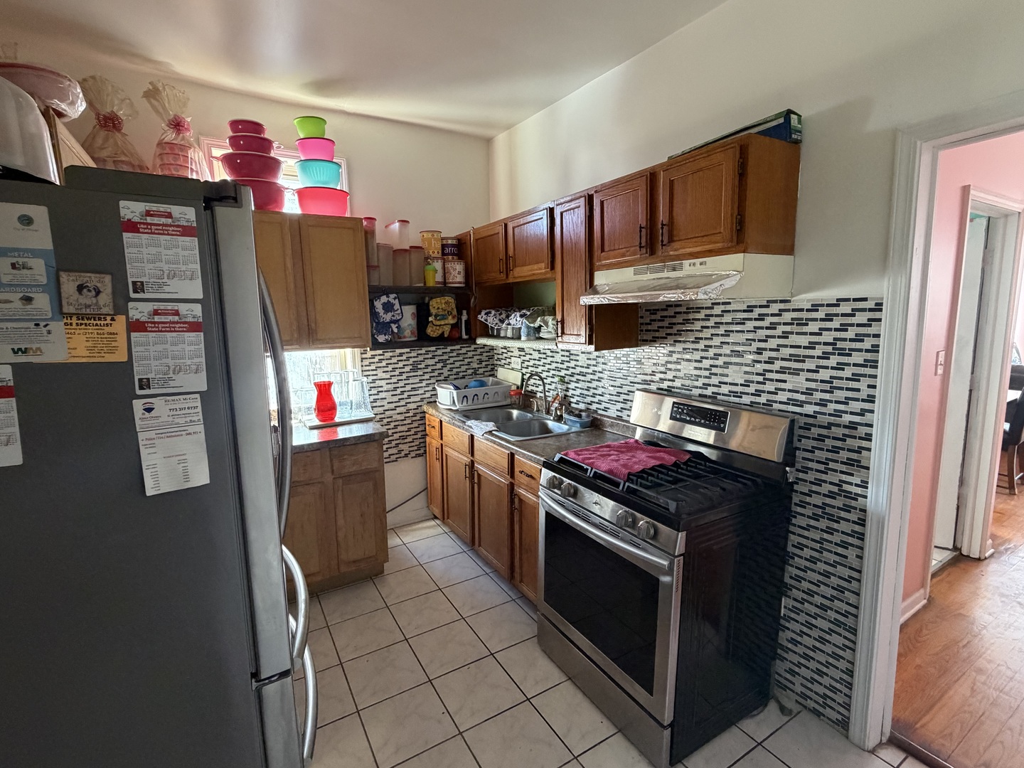 10045 South Ave M Chicago, IL 60617 - Photo 11 of 25 a kitchen with stainless steel appliances granite countertop a stove a refrigerator and a refrigerator