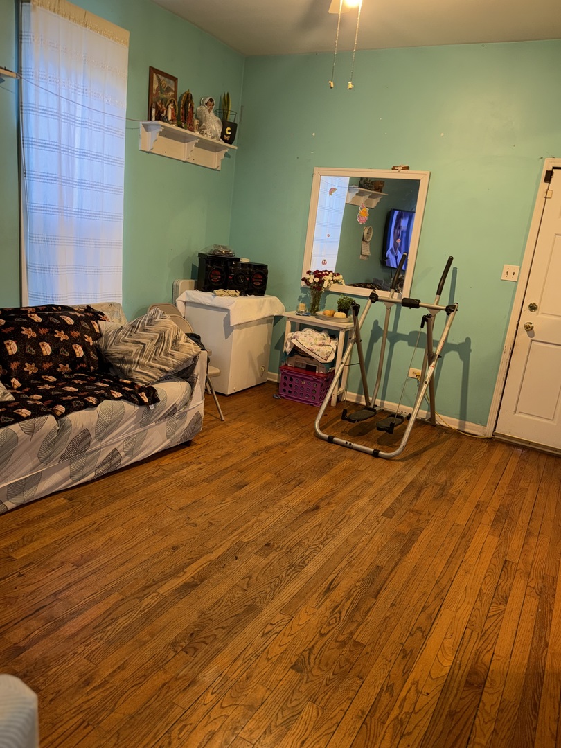 10045 South Ave M Chicago, IL 60617 - Photo 14 of 25 a bedroom with furniture and a wooden floor