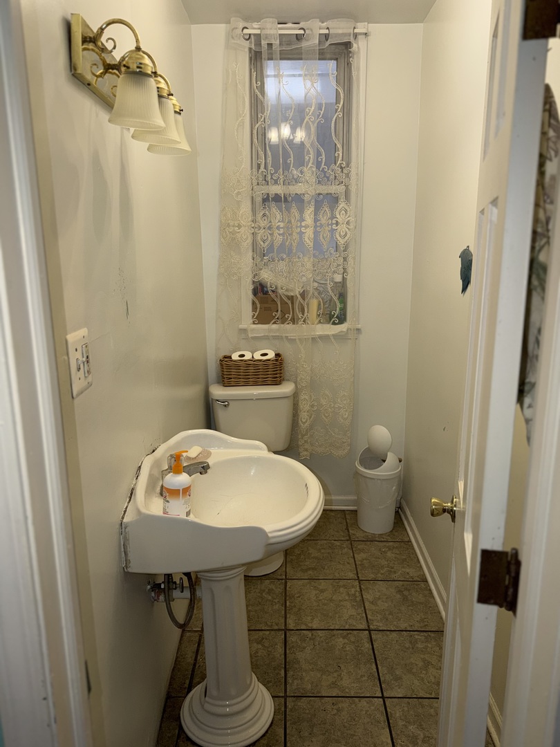 10045 South Ave M Chicago, IL 60617 - Photo 16 of 25 a bathroom with a sink toilet and shower
