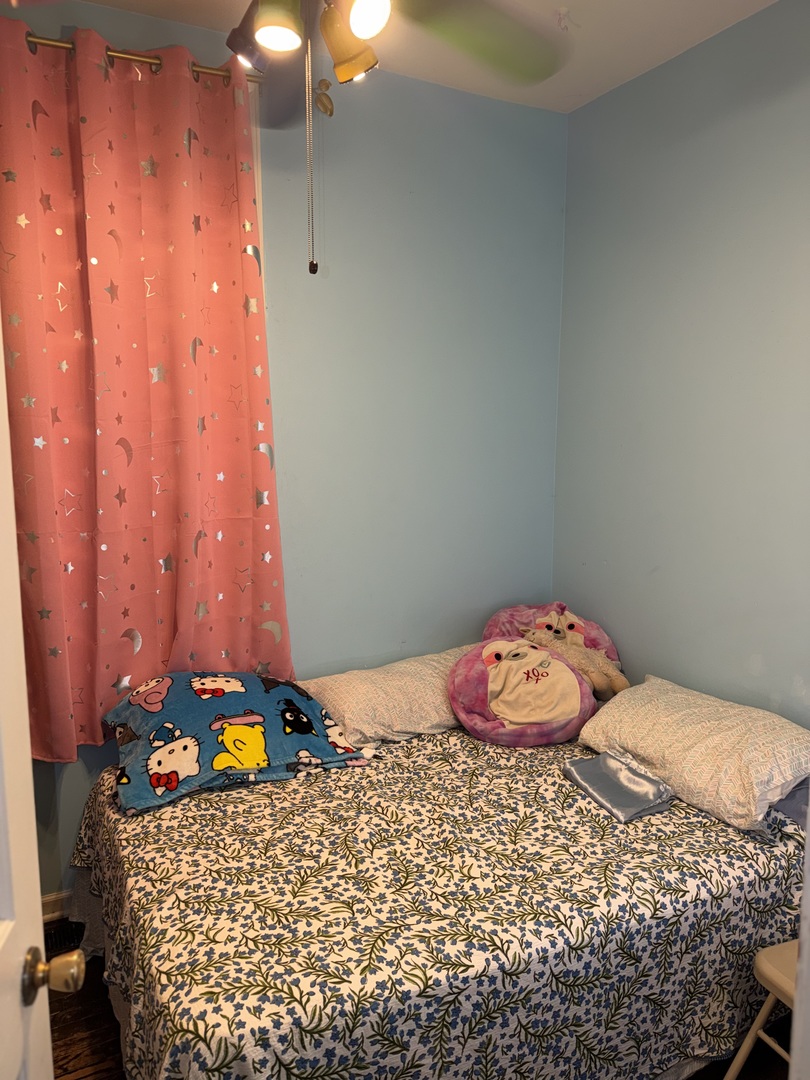 10045 South Ave M Chicago, IL 60617 - Photo 17 of 25 a bedroom with a bed and a table