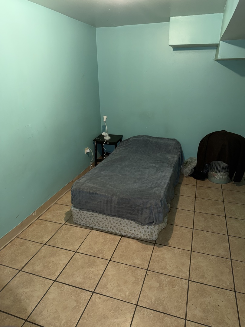 10045 South Ave M Chicago, IL 60617 - Photo 22 of 25 a bedroom with a bed and a window