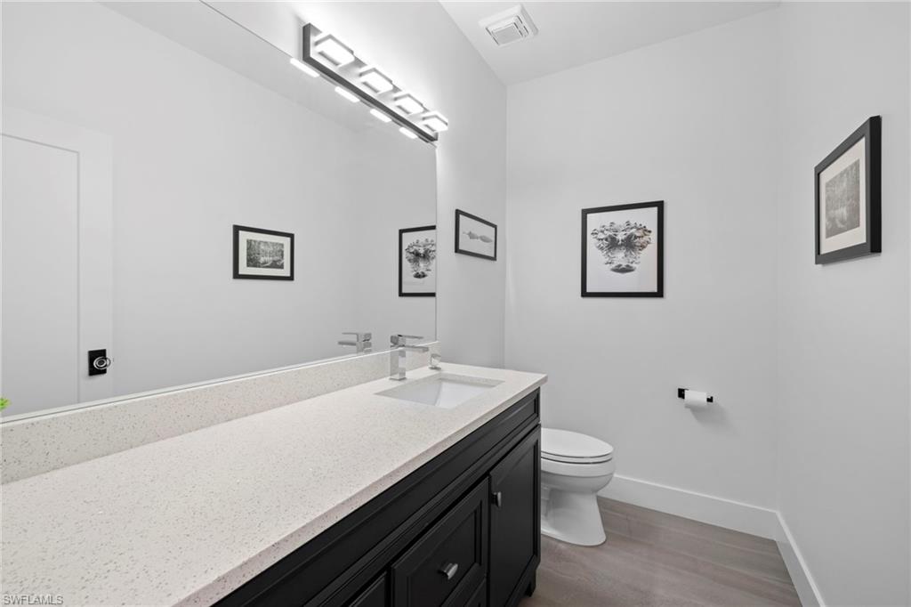 6903 Mauna Loa Lane Naples, FL 34113 - Photo 36 of 46 a bathroom with a sink a toilet and mirror