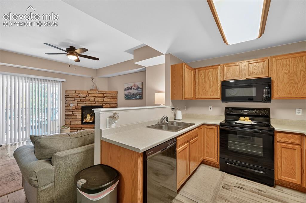 2141 Legacy Ridge View, Unit 109 Colorado Springs, CO 80910 - Photo 7 of 23 a kitchen with a stove a sink and a microwave