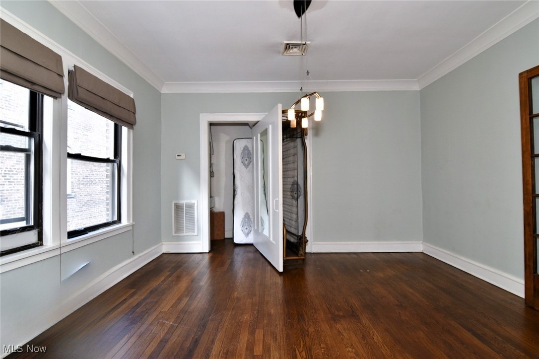 2469 Overlook Road, Unit 8 Cleveland, OH 44106 - Photo 9 of 24 Unfurnished dining area with crown molding, dark wood-type flooring, and a chandelier