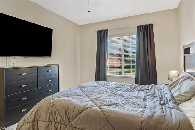 a bedroom with a large bed and a flat screen tv