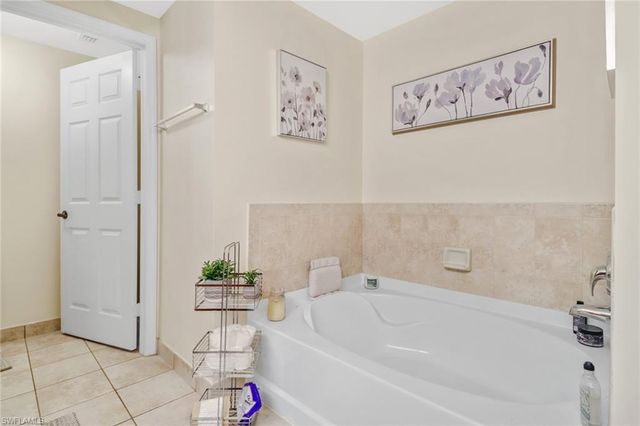 a white bath tub sitting next to a white sink and vanity