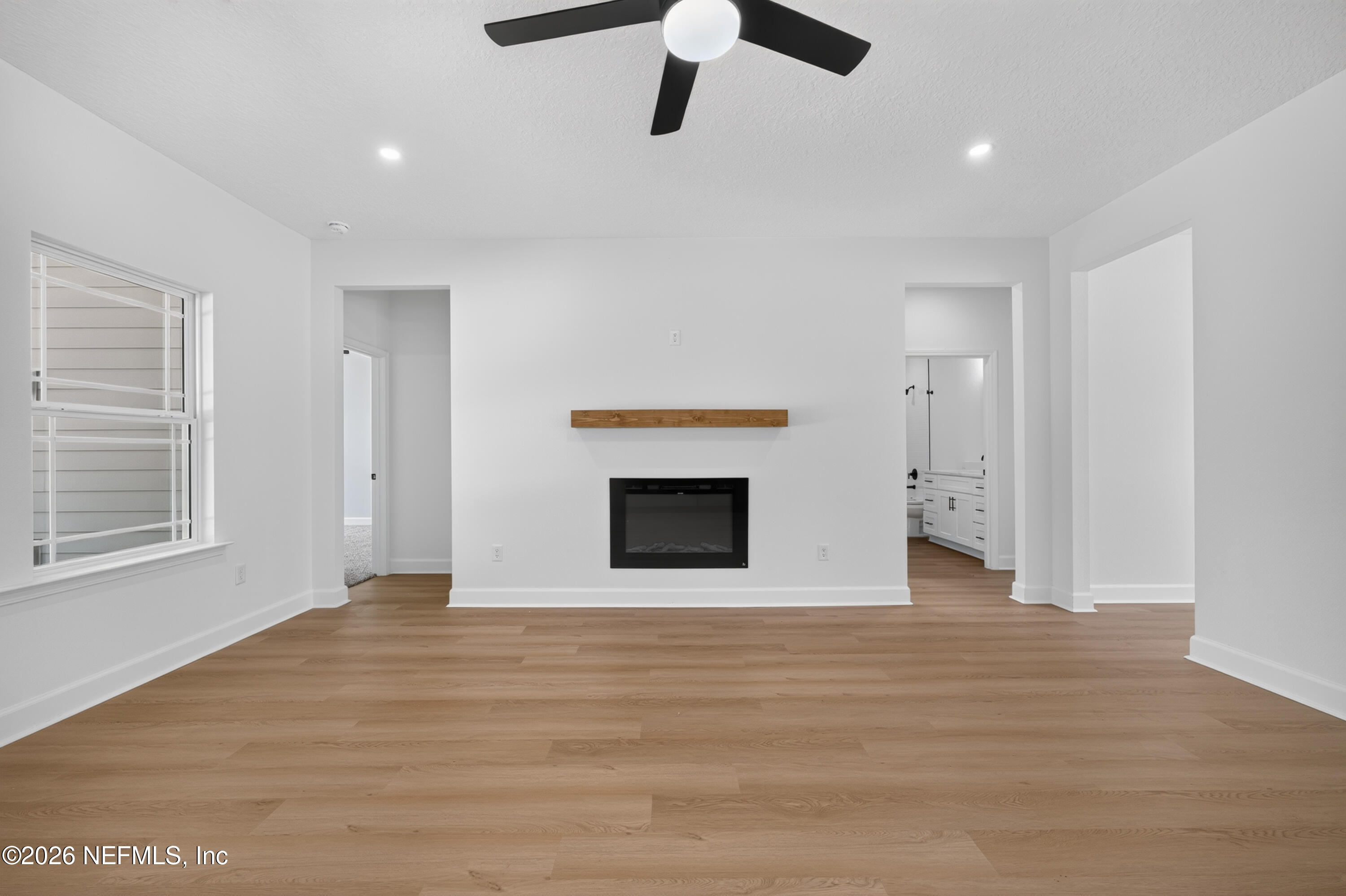 4362 Angora Street Middleburg, FL 32068 - Photo 9 of 31 a view of an empty room with wooden floor fireplace and a window