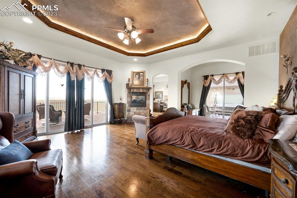 19625 Drennan Road Colorado Springs, CO 80928 - Photo 18 of 50 a spacious bedroom with a bed couch chandelier and a large window