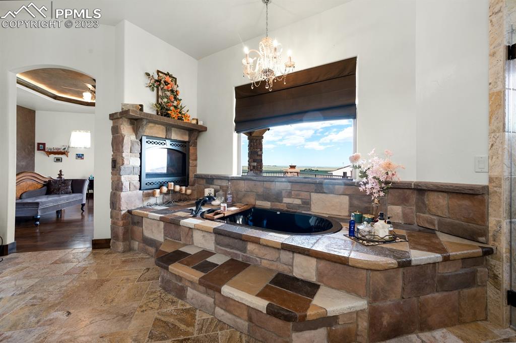 19625 Drennan Road Colorado Springs, CO 80928 - Photo 20 of 50 Master Level - Master Spa Bath with gas fireplace and crystal chandelier.