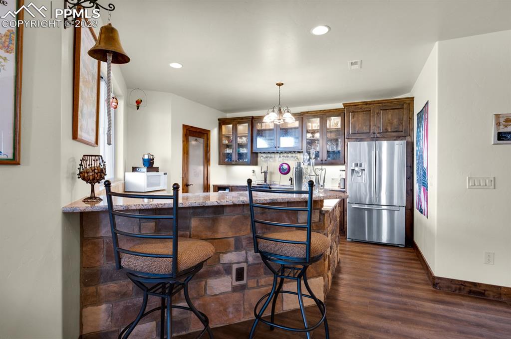 19625 Drennan Road Colorado Springs, CO 80928 - Photo 30 of 50 a kitchen with stainless steel appliances wooden floor and dining table