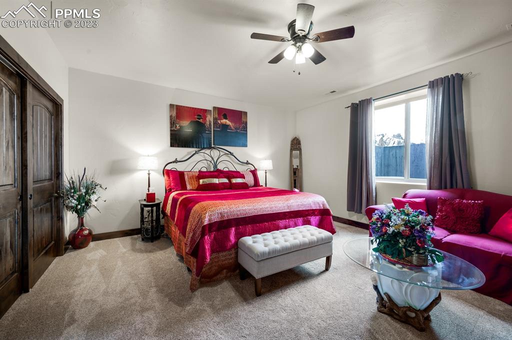 19625 Drennan Road Colorado Springs, CO 80928 - Photo 31 of 50 a bedroom with a bed and a chandelier