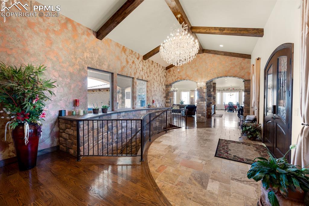 19625 Drennan Road Colorado Springs, CO 80928 - Photo 7 of 50 Grand Foyer with travertine tile, wood floors and crystal chandelier.