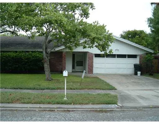a view of a yard in front of a house with large trees