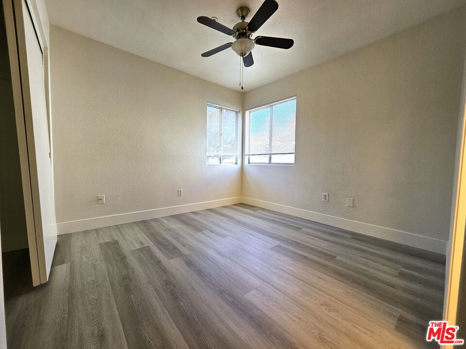7254 Brienza Place Rancho Cucamonga, CA 91701 - Photo 11 of 17 an empty room with wooden floor and windows