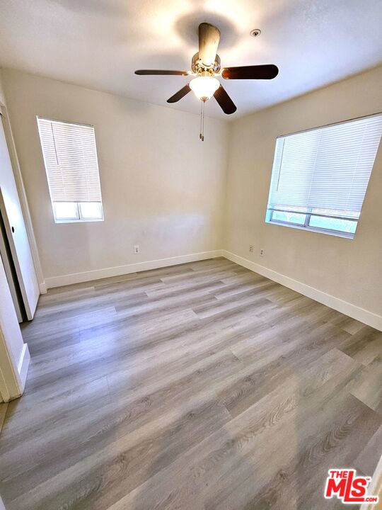 7254 Brienza Place Rancho Cucamonga, CA 91701 - Photo 7 of 17 a view of an empty room with a window and wooden floor