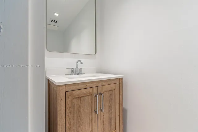 a utility room with a sink a mirror and a vanity