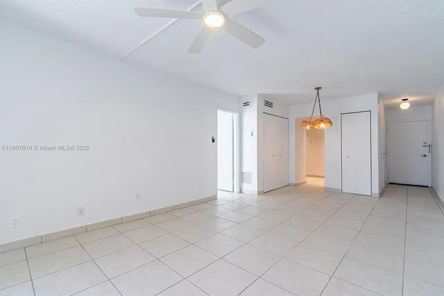 an empty room with a ceiling fan and window