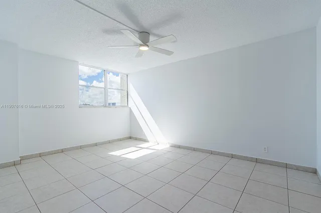 an empty room with windows and fan