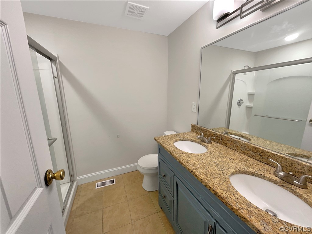 9407 Emmett Road Glen Allen, VA 23060 - Photo 8 of 18 a bathroom with a granite countertop sink a mirror and a toilet