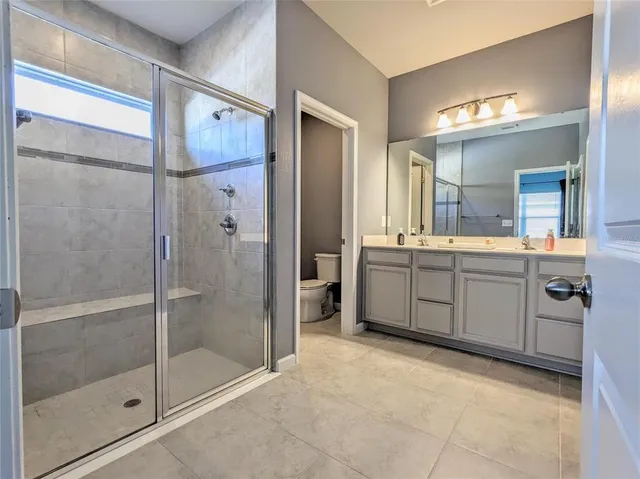 a spacious bathroom with a shower sink and mirror
