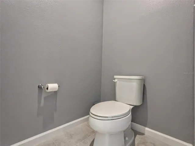 a white toilet sitting next to a white wall