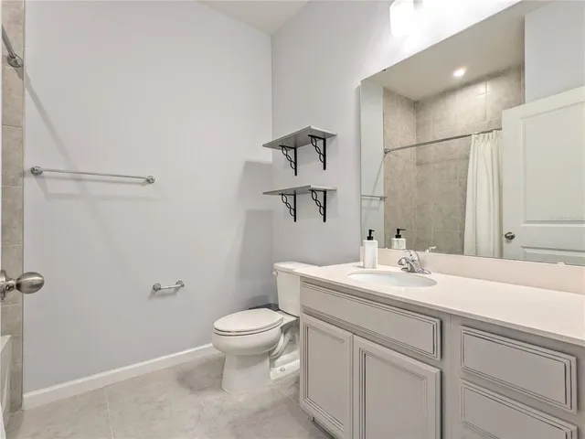 a bathroom with a granite countertop sink a toilet and a mirror