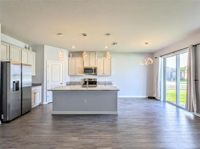 a kitchen with stainless steel appliances a refrigerator sink and cabinets