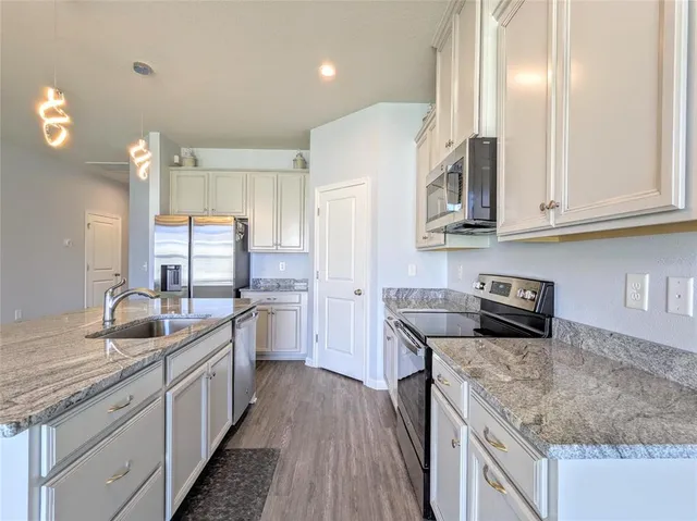 a kitchen with stainless steel appliances granite countertop a sink stove and refrigerator