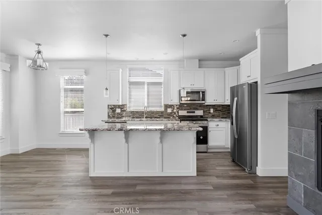 a kitchen with a refrigerator cabinets and wooden floor