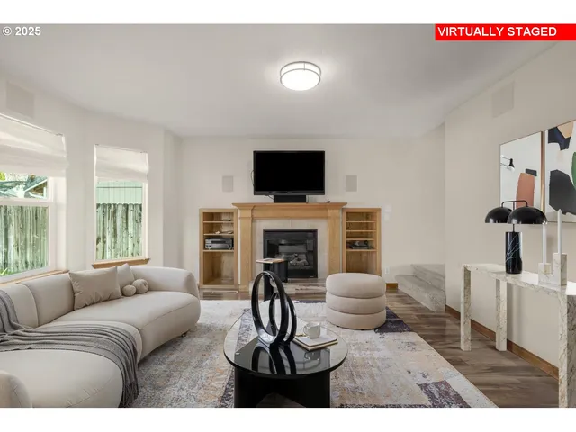 a living room with furniture a flat screen tv and a fireplace