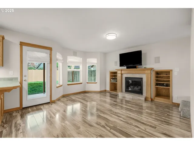 a view of an empty room with a fireplace and a window