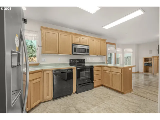 a kitchen with a refrigerator stove top oven and sink