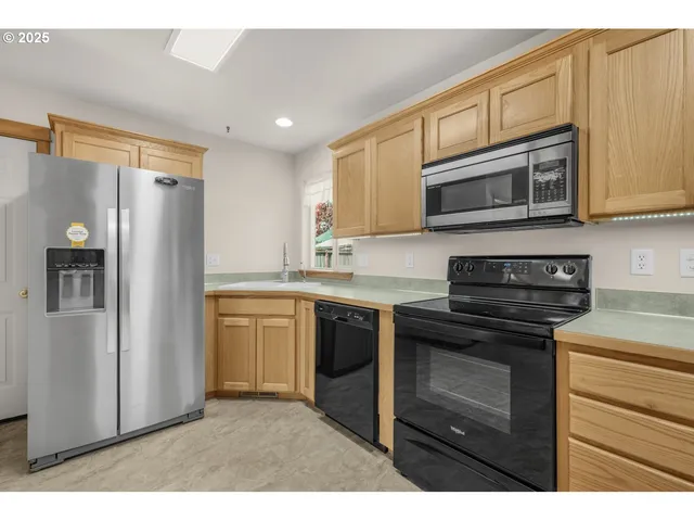 a kitchen with stainless steel appliances granite countertop a refrigerator stove and sink