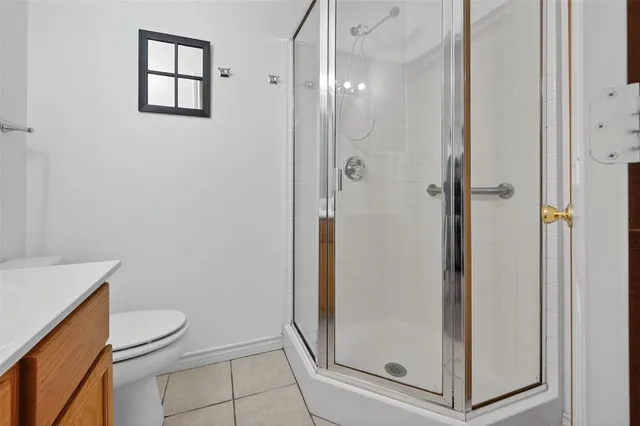 a bathroom with a granite countertop shower and toilet