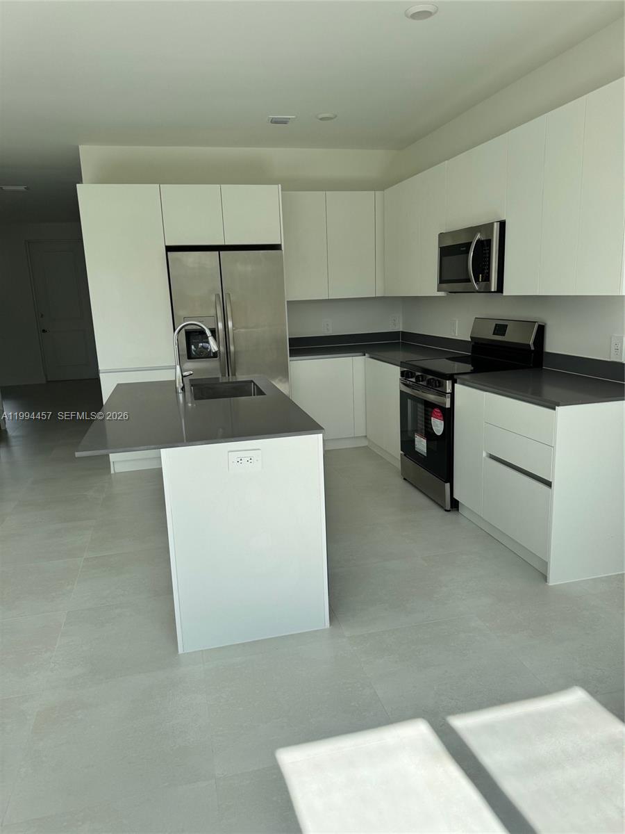 18945 Southwest 344th Terrace Homestead, FL 33034 - Photo 8 of 12 a kitchen with stainless steel appliances a sink a stove top oven a counter space and cabinets
