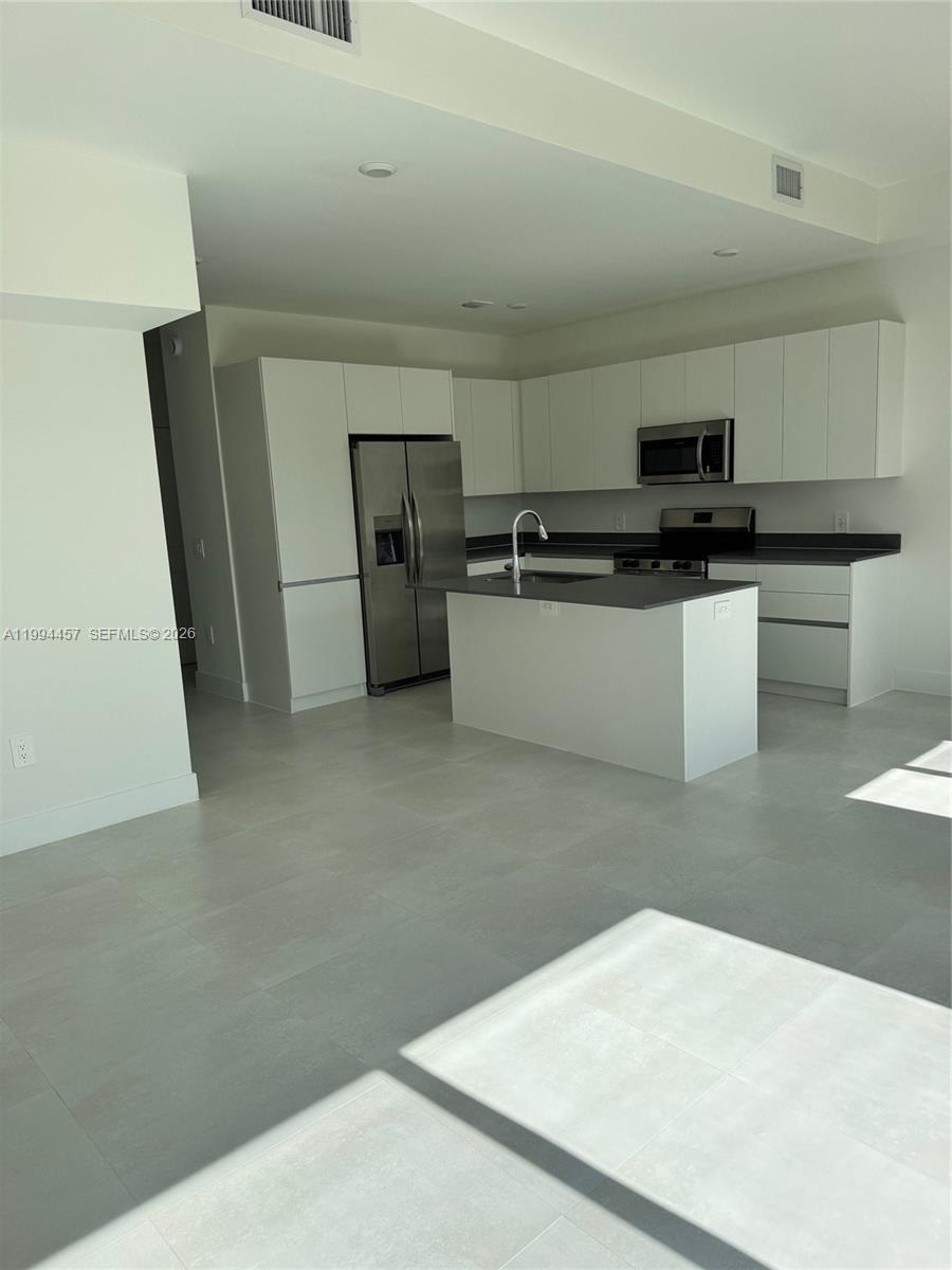 18945 Southwest 344th Terrace Homestead, FL 33034 - Photo 9 of 12 a kitchen with stainless steel appliances a refrigerator and a stove top oven