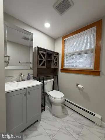 a bathroom with a toilet sink a mirror and vanity
