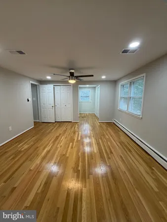 a view of empty room with wooden floor