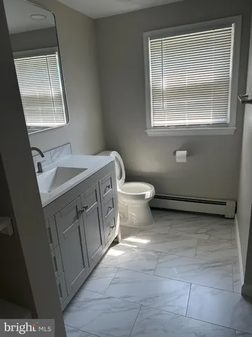 a bathroom with a sink a toilet and a mirror