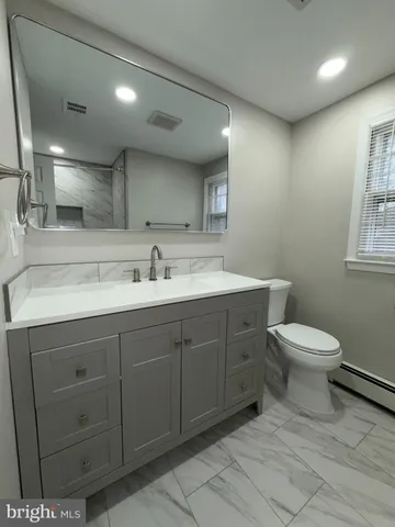a spacious bathroom with a toilet sink and mirror