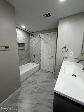 a bathroom with a tub sink and shower