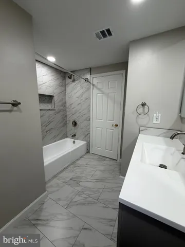 a bathroom with a tub sink and shower