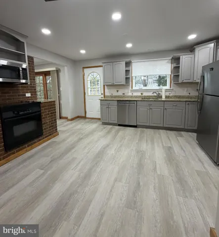 a view of kitchen with wooden floor and electronic appliances