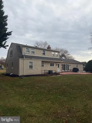 a view of a big house with a big yard and large trees