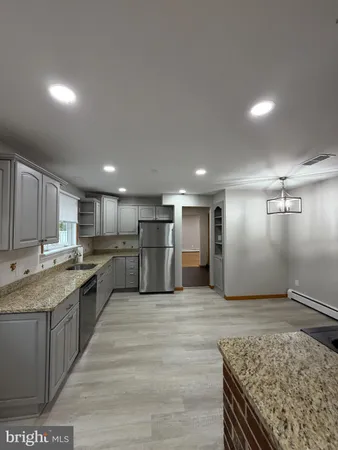 a large kitchen with kitchen island a sink stainless steel appliances and cabinets