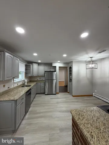 a large kitchen with kitchen island a sink stainless steel appliances and cabinets