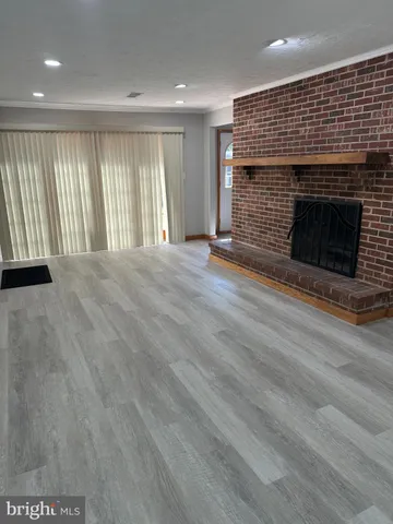 an empty room with windows and fireplace